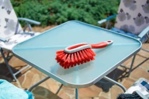 НА фото: щетка с мягким ворсом для ухода за садовой мебелью.
